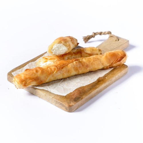 Two rolled pastries on a wooden board with a white background